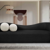 black modern sofa in lounge with neutral rug and paint. Two round pillows on the left.